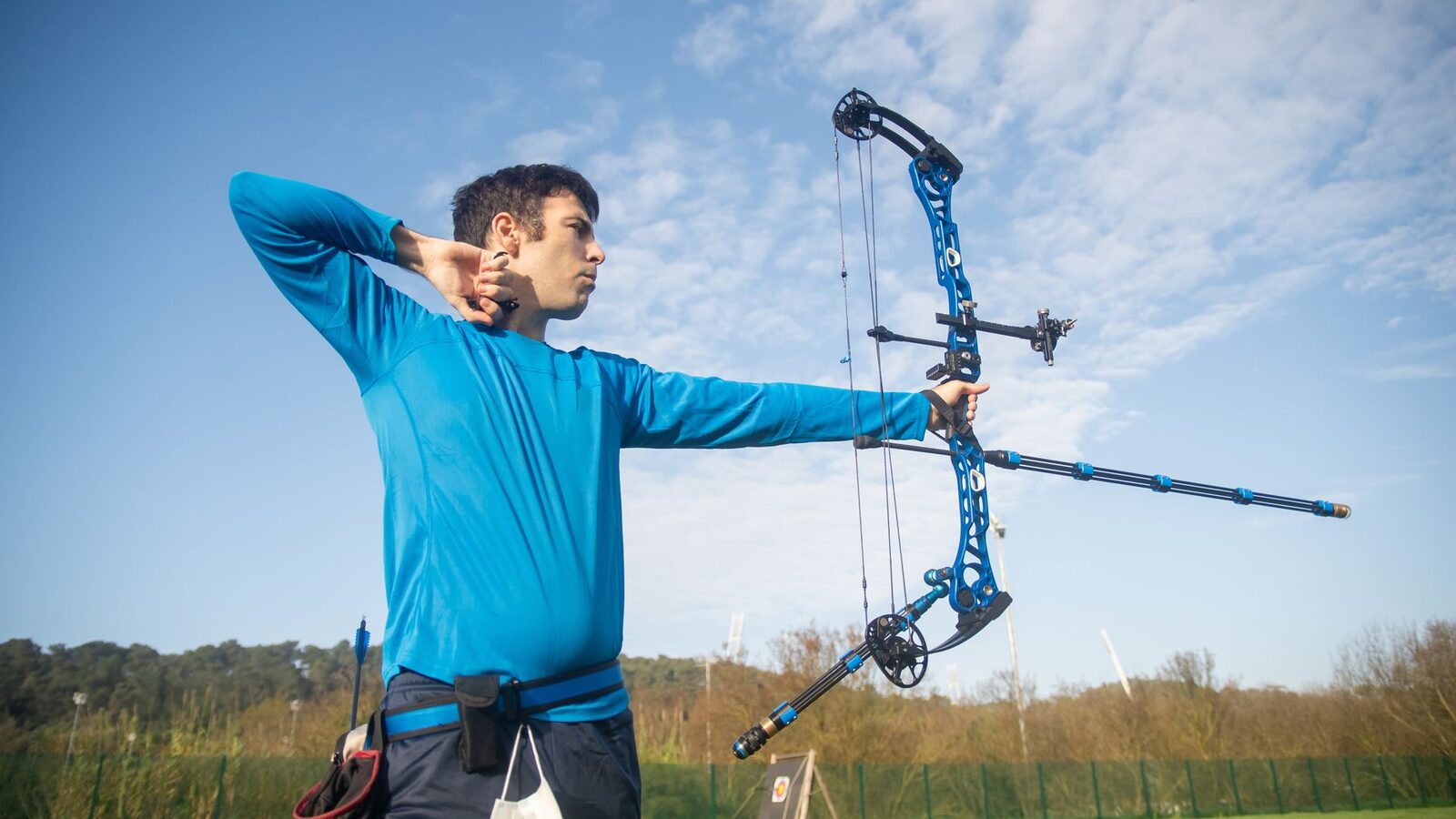 Archer adulte en extérieur visant avec un arc à poulies compact