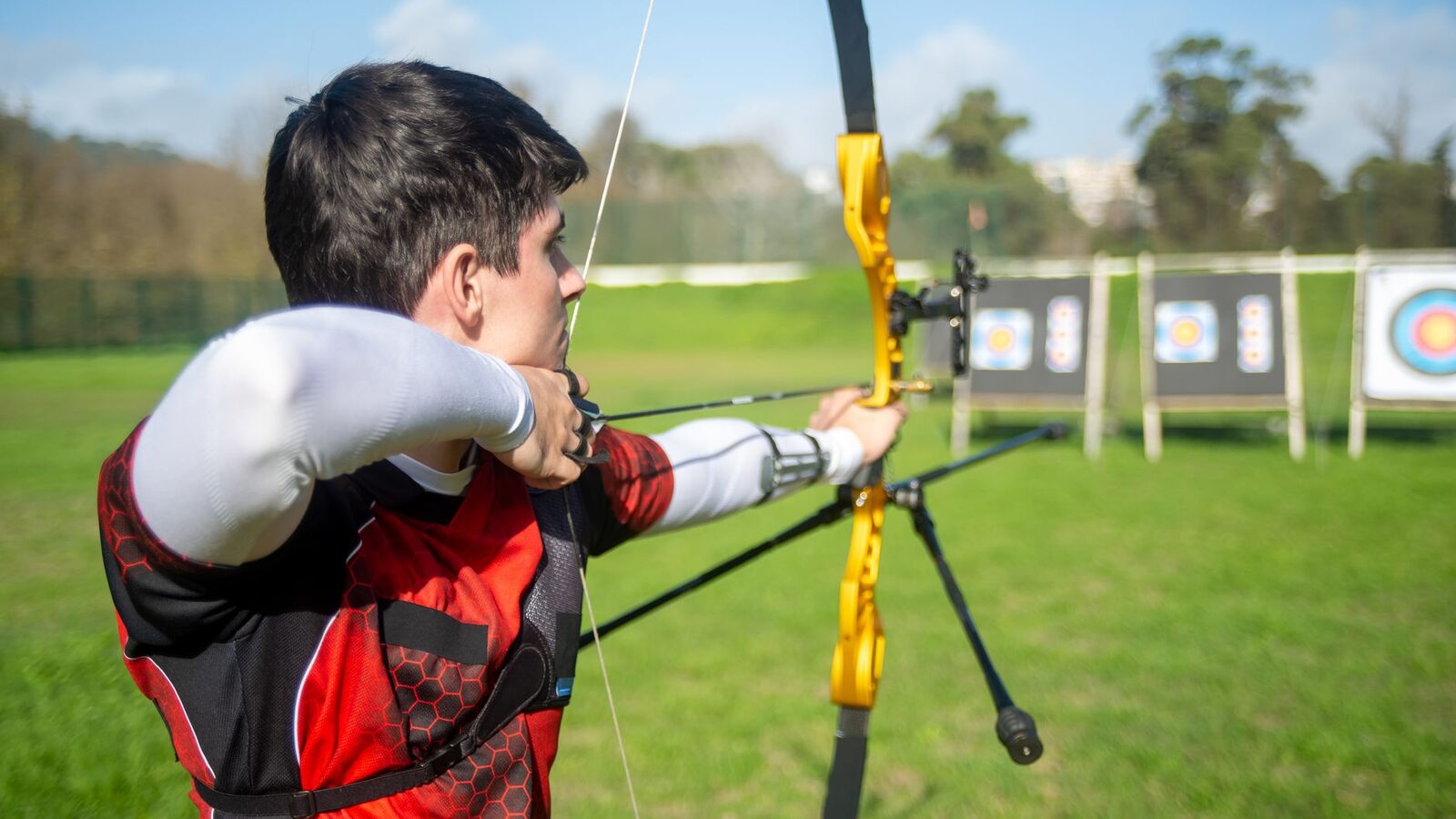 Archer visant une cible sur un terrain extérieur dégagé